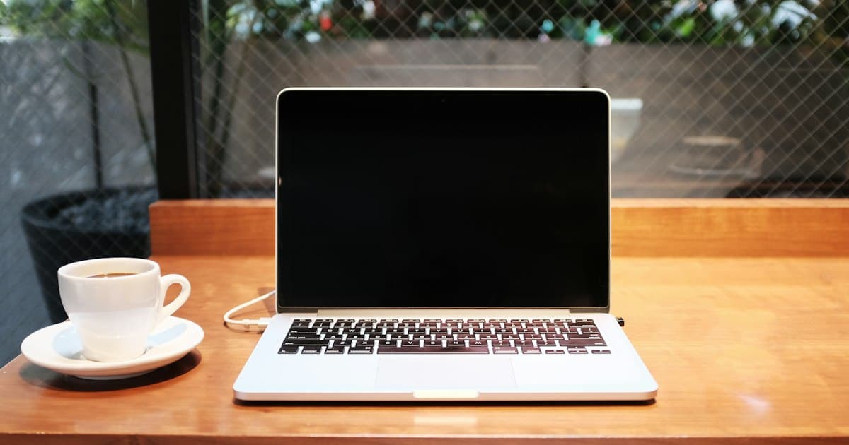 Ordinateur portable et tasse sur une table en bois