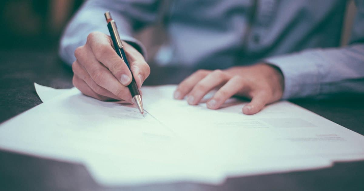 Personne prenant des notes sur des documents