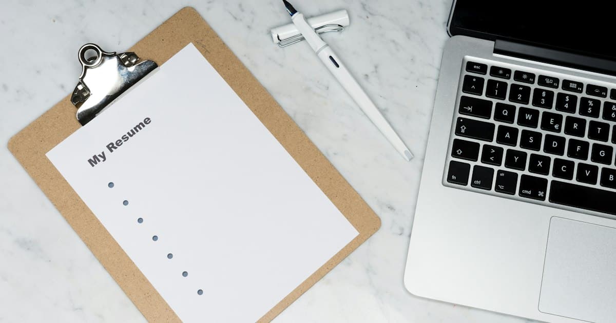 Porte-documents, stylo et ordinateur portable posés sur un bureau